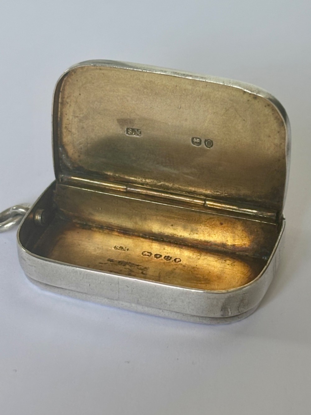 A small rectangular Victorian silver vesta case featuring horizontal reeded engine-turned decoration and an attached side suspension ring. View XIII