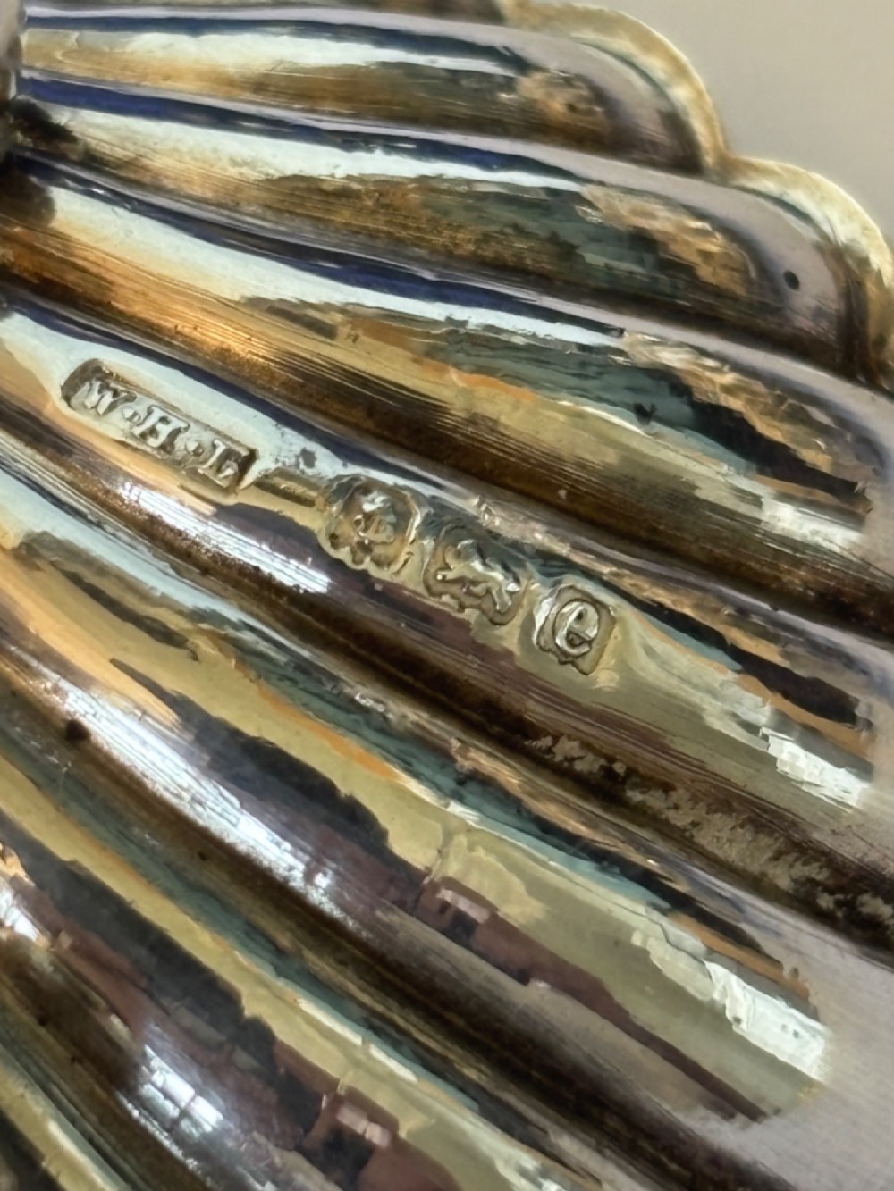 An open fitted presentation case containing two shell-shaped silver salt cellars with gilded interiors and two matching shell-bowl spoons. View III