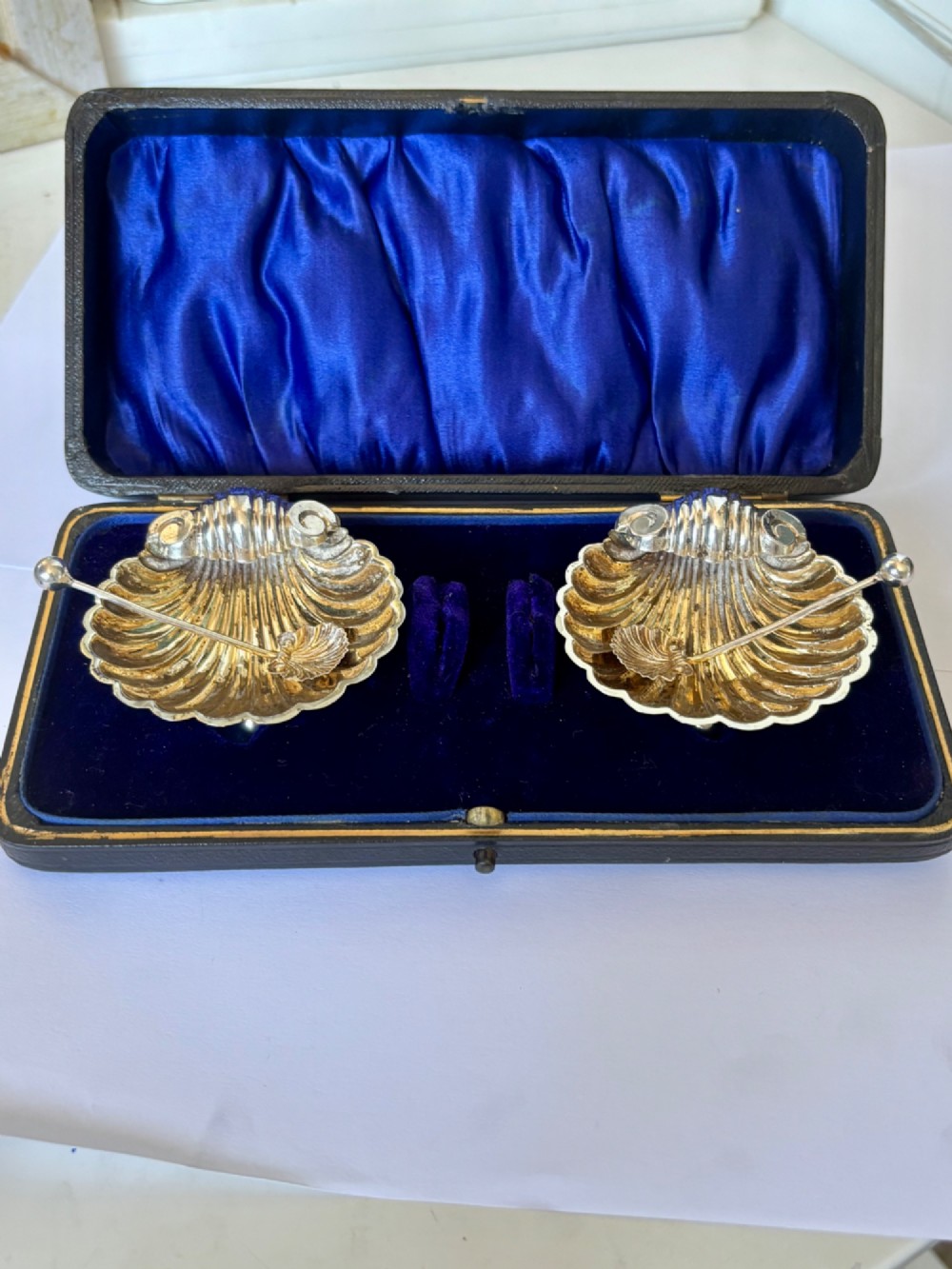 An open fitted presentation case containing two shell-shaped silver salt cellars with gilded interiors and two matching shell-bowl spoons. View VII