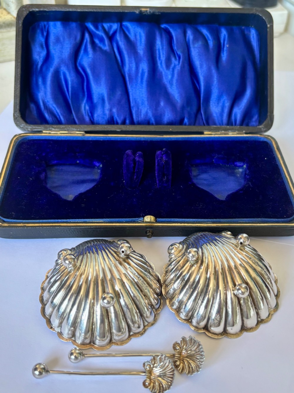 An open fitted presentation case containing two shell-shaped silver salt cellars with gilded interiors and two matching shell-bowl spoons. View VIII