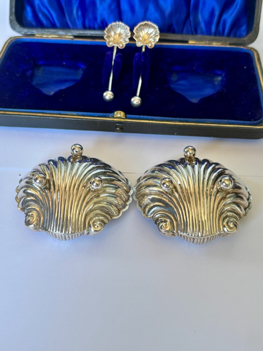 An open fitted presentation case containing two shell-shaped silver salt cellars with gilded interiors and two matching shell-bowl spoons. View XIII