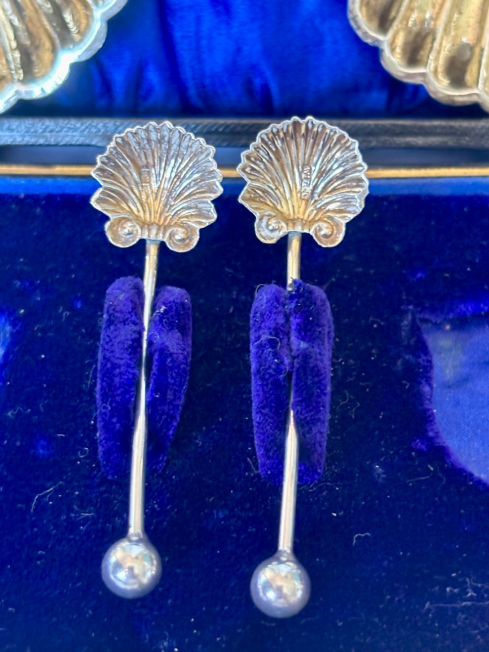 An open fitted presentation case containing two shell-shaped silver salt cellars with gilded interiors and two matching shell-bowl spoons. View XIV