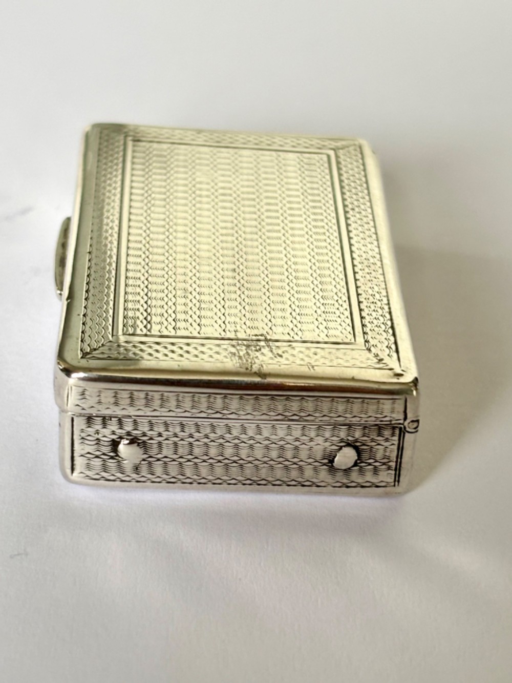 A small rectangular sterling silver snuff box with engine-turned basketweave engraving and a hinged lid. View VIII