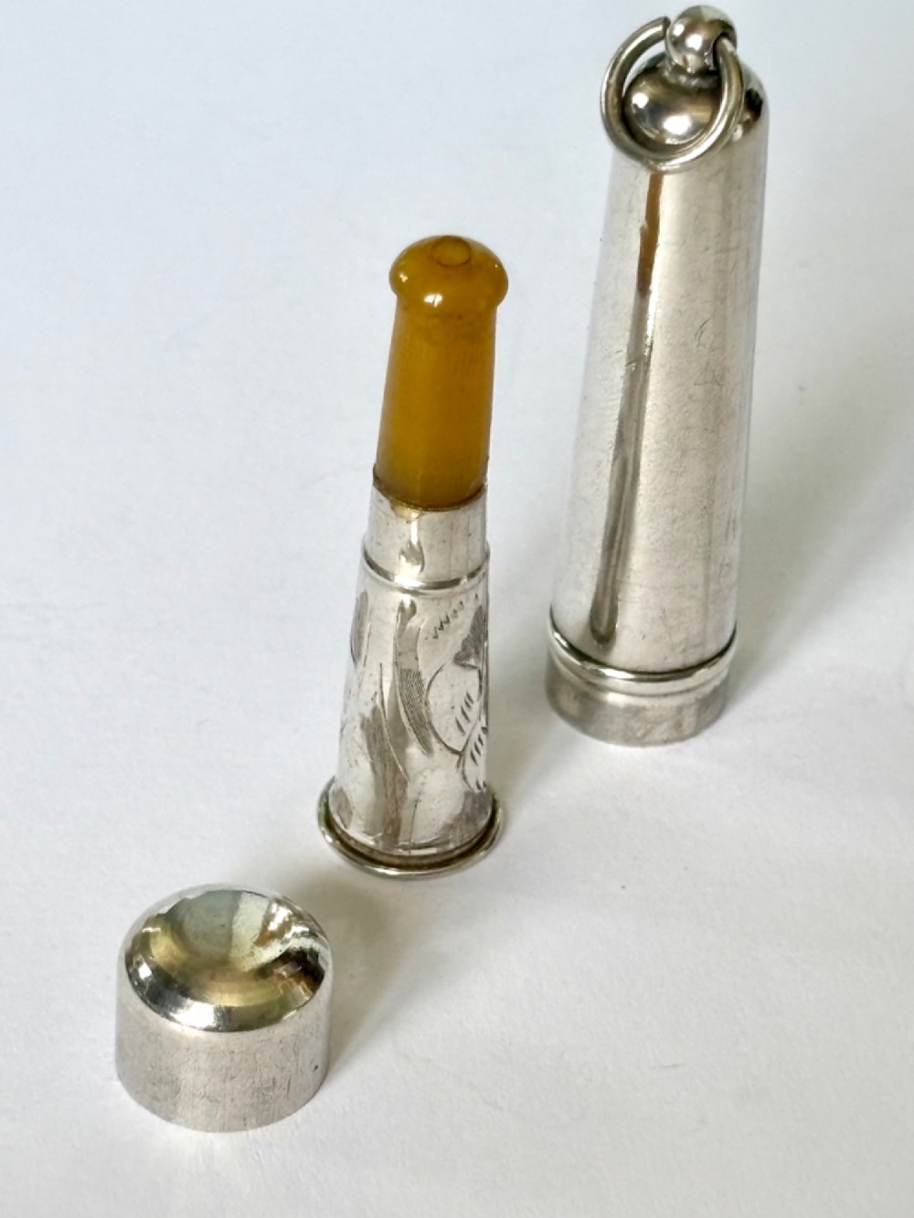 A George V sterling silver cheroot holder case with scroll engraving and a fitted amber mouthpiece.