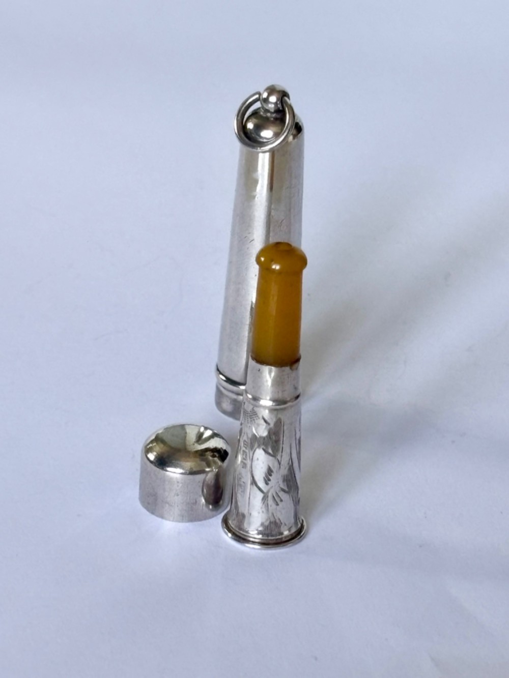 A George V sterling silver cheroot holder case with scroll engraving and a fitted amber mouthpiece. View II