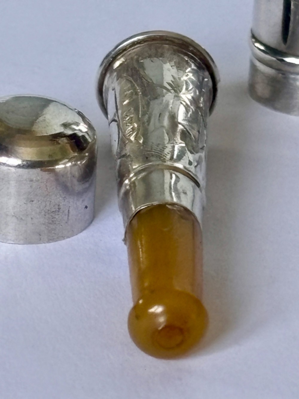 A George V sterling silver cheroot holder case with scroll engraving and a fitted amber mouthpiece. View V