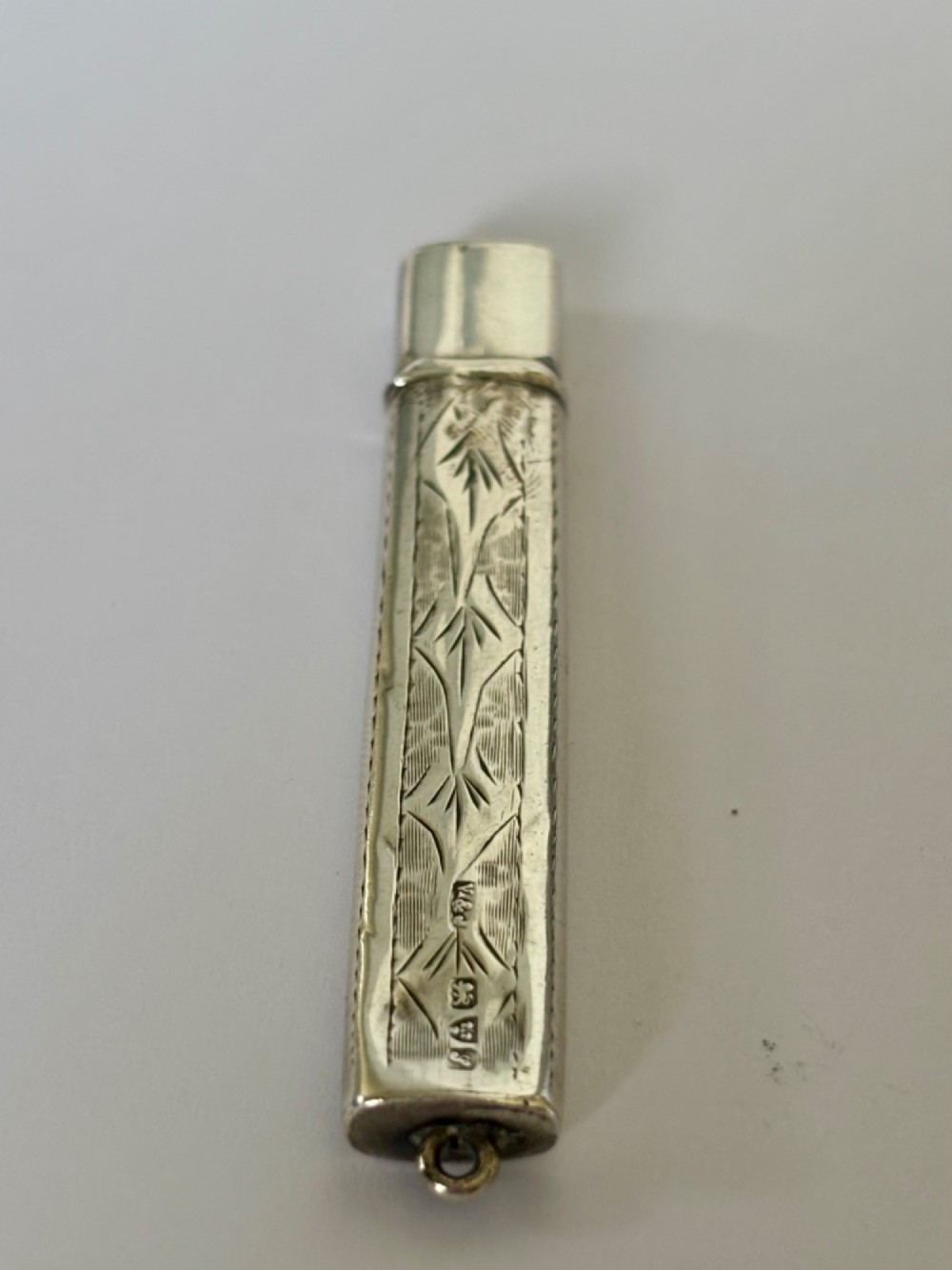An engraved rectangular sterling silver pencil case featuring botanical foliage engraving and Chester hallmark stampings from 1918. View II