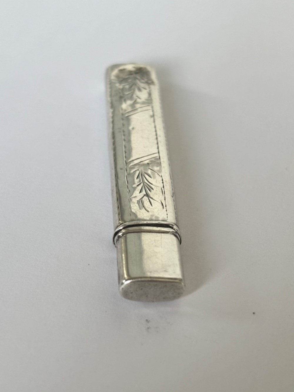 An engraved rectangular sterling silver pencil case featuring botanical foliage engraving and Chester hallmark stampings from 1918. View IV