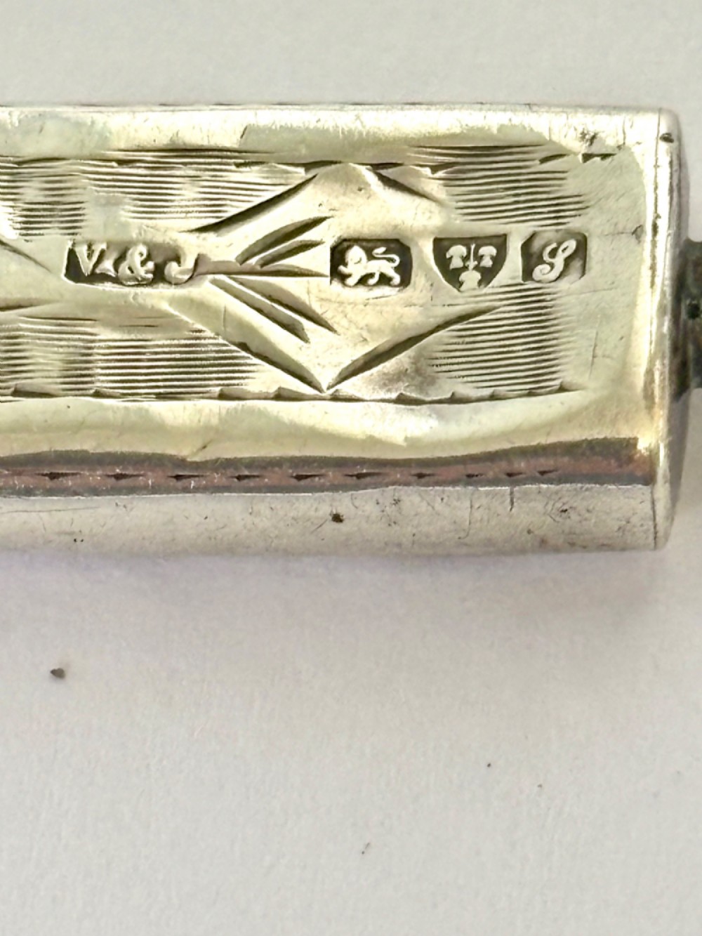 An engraved rectangular sterling silver pencil case featuring botanical foliage engraving and Chester hallmark stampings from 1918. View VI