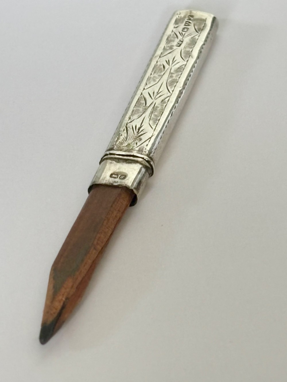 An engraved rectangular sterling silver pencil case featuring botanical foliage engraving and Chester hallmark stampings from 1918. View VII