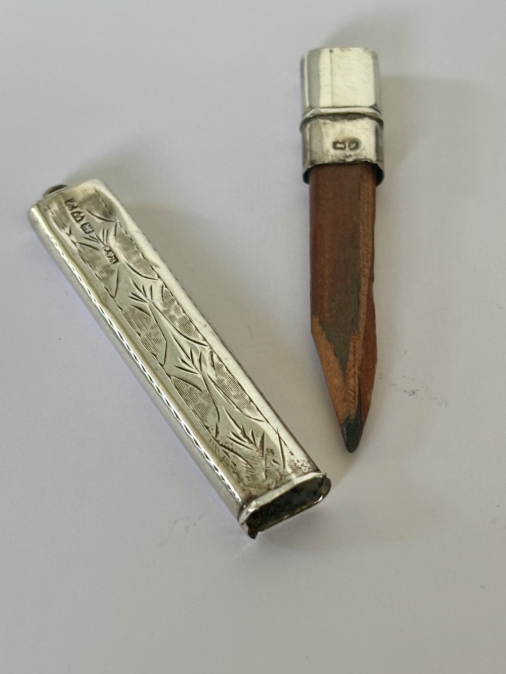 An engraved rectangular sterling silver pencil case featuring botanical foliage engraving and Chester hallmark stampings from 1918. View IX