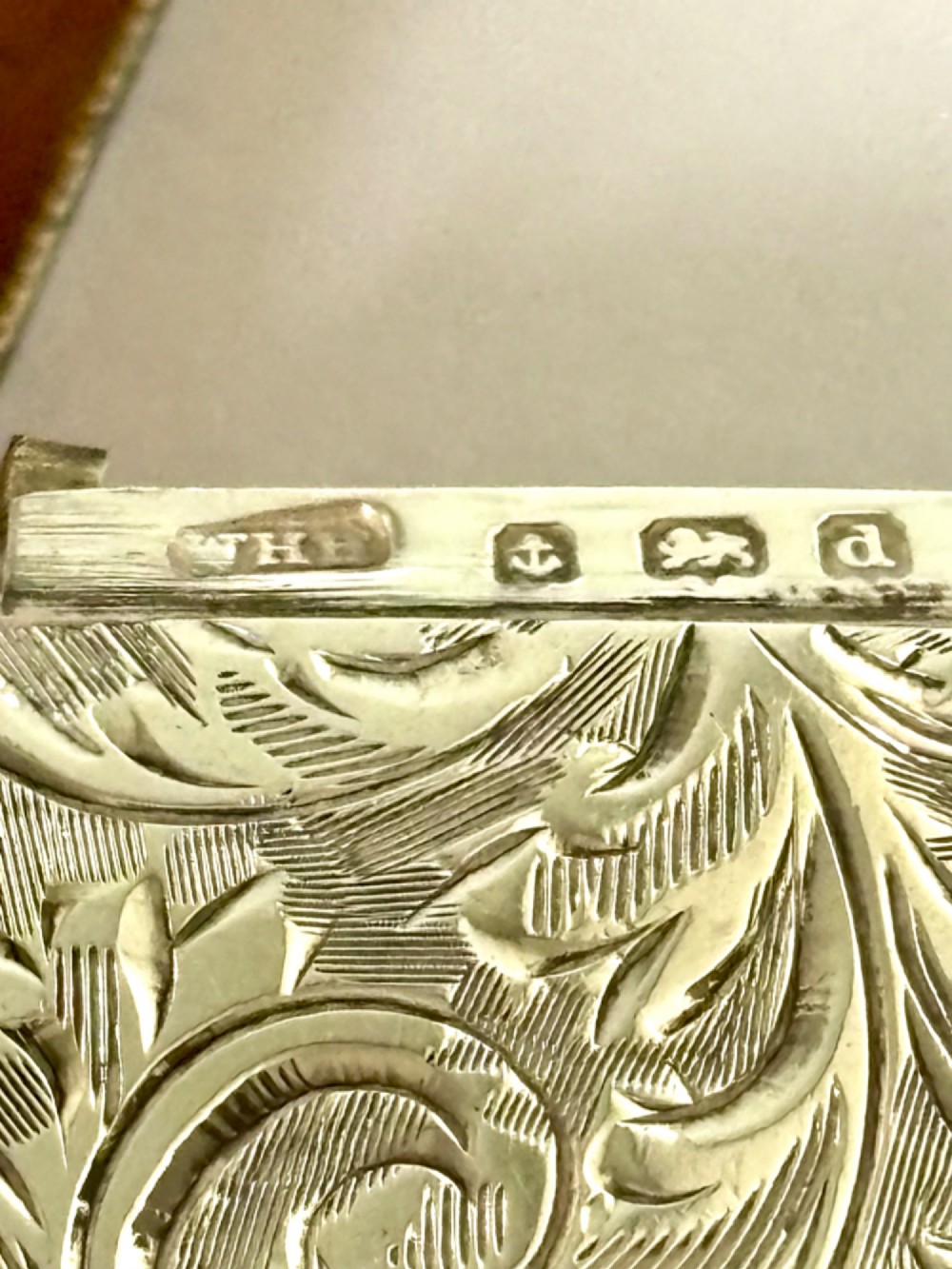 An Edwardian silver vesta case decorated with intricate foliate scroll engraving and a central monogrammed cartouche. View VII