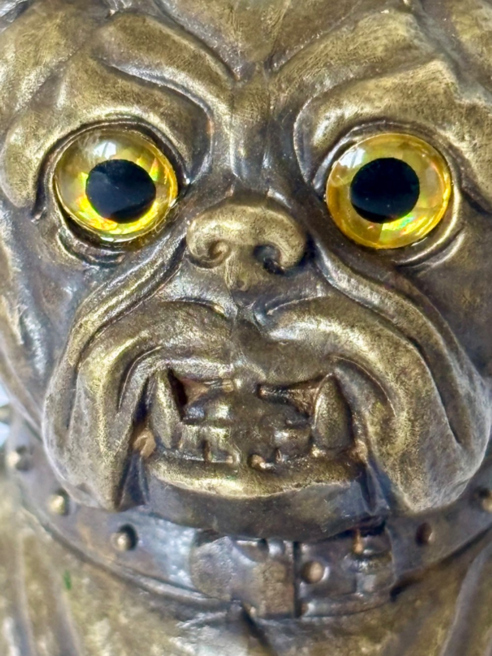 A cast brass table-top vesta case sculpted in the form of a bulldog head featuring inset yellow glass eyes and a studded collar. View V