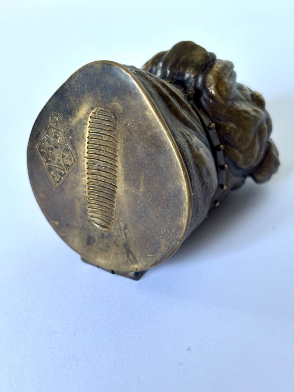 A cast brass table-top vesta case sculpted in the form of a bulldog head featuring inset yellow glass eyes and a studded collar. View VII