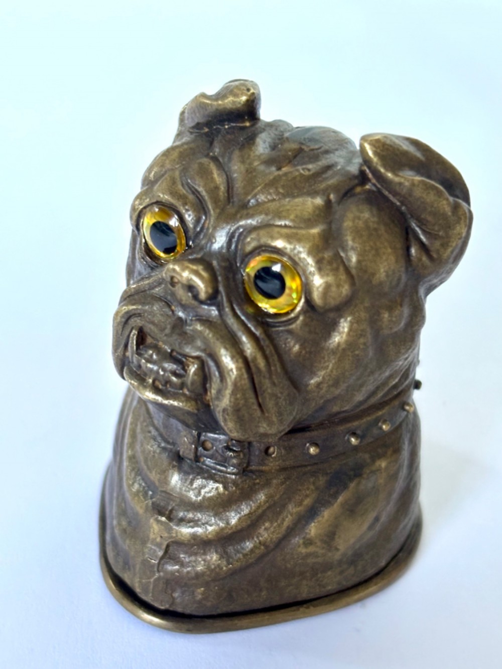 A cast brass table-top vesta case sculpted in the form of a bulldog head featuring inset yellow glass eyes and a studded collar. View VIII
