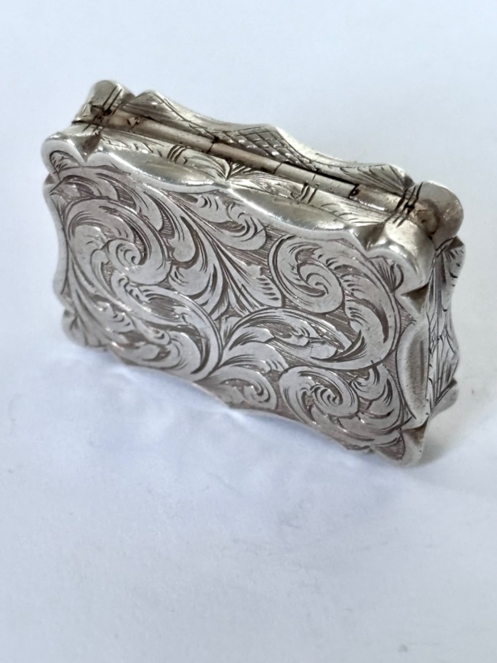 An open early Victorian rectangular silver-gilt vinaigrette showing hallmarks inside the lid and a detailed pierced foliate interior grille. View III
