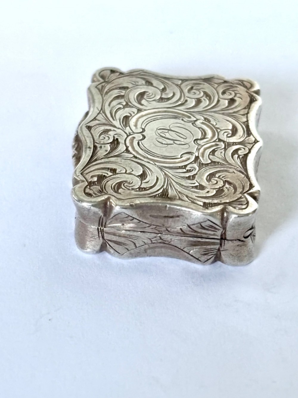 An open early Victorian rectangular silver-gilt vinaigrette showing hallmarks inside the lid and a detailed pierced foliate interior grille. View VI