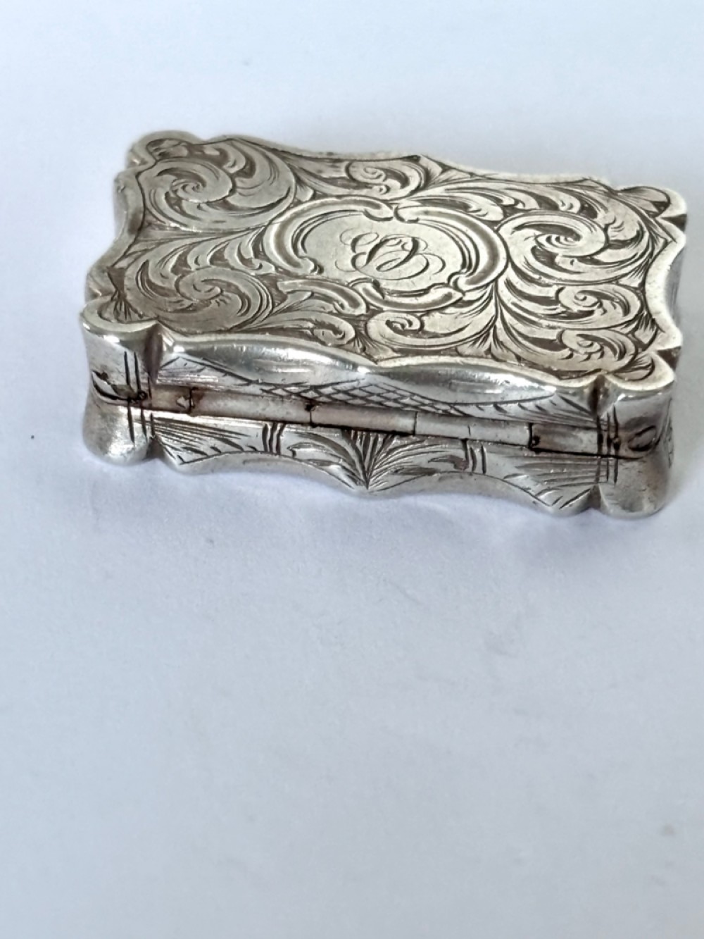 An open early Victorian rectangular silver-gilt vinaigrette showing hallmarks inside the lid and a detailed pierced foliate interior grille. View VII