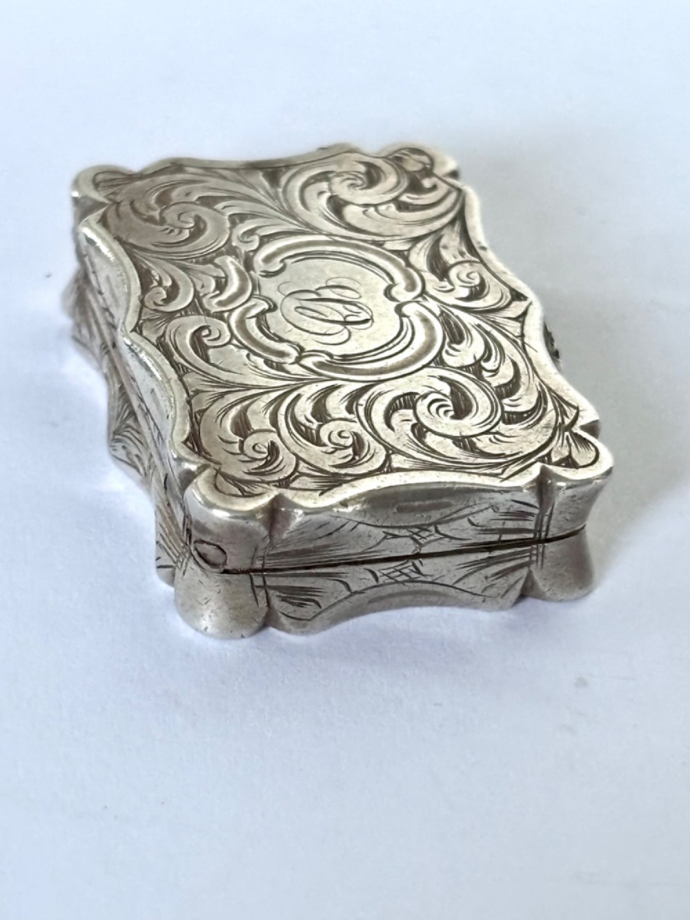 An open early Victorian rectangular silver-gilt vinaigrette showing hallmarks inside the lid and a detailed pierced foliate interior grille. View IX