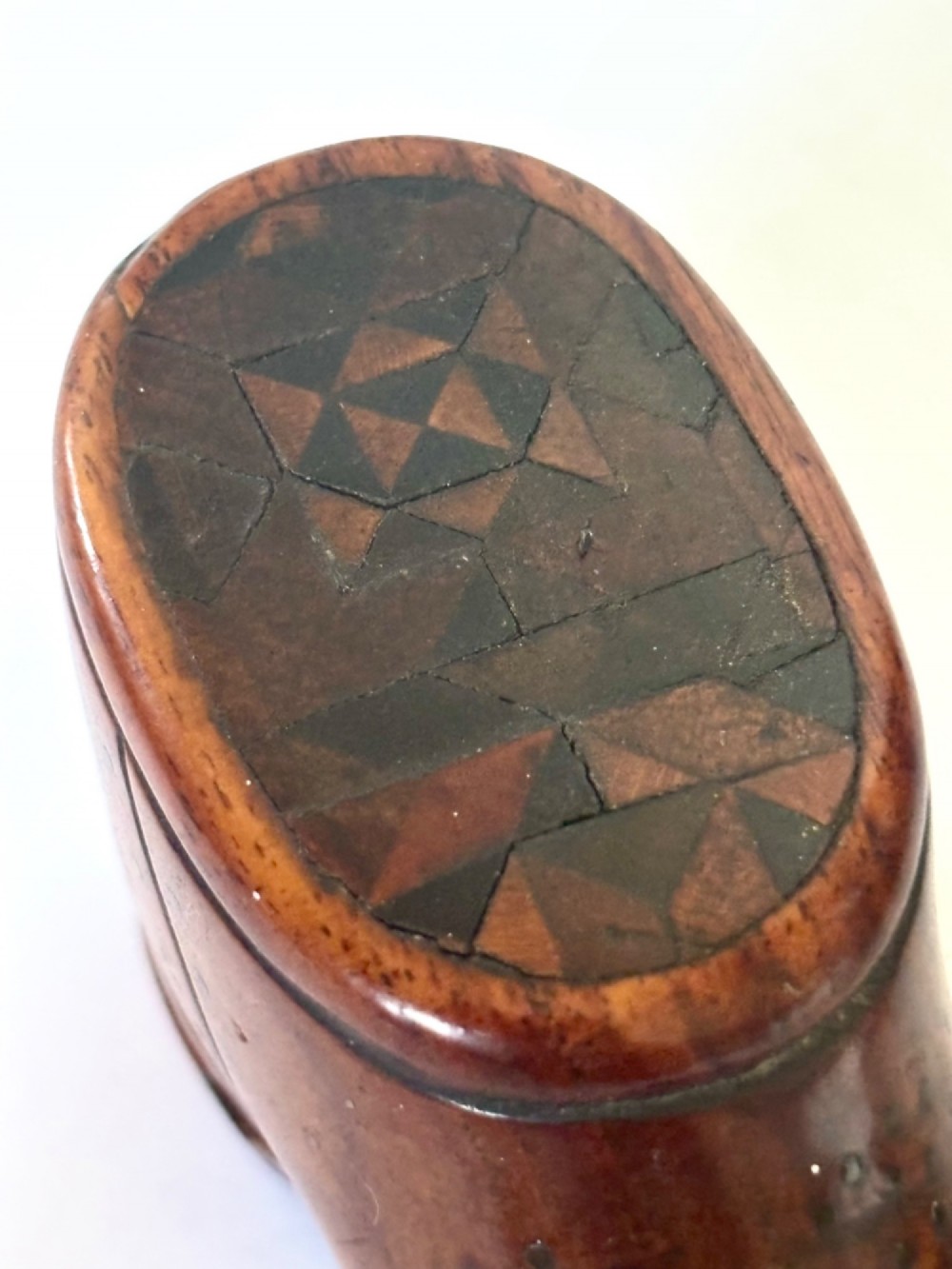 A 19th-century carved wooden shoe-form snuff box featuring brass pique pinwork and a geometric parquetry inlaid lid. View II