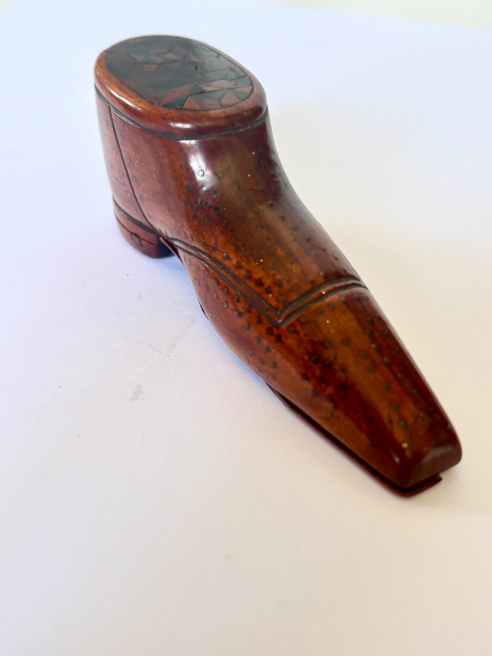 A 19th-century carved wooden shoe-form snuff box featuring brass pique pinwork and a geometric parquetry inlaid lid. View IV