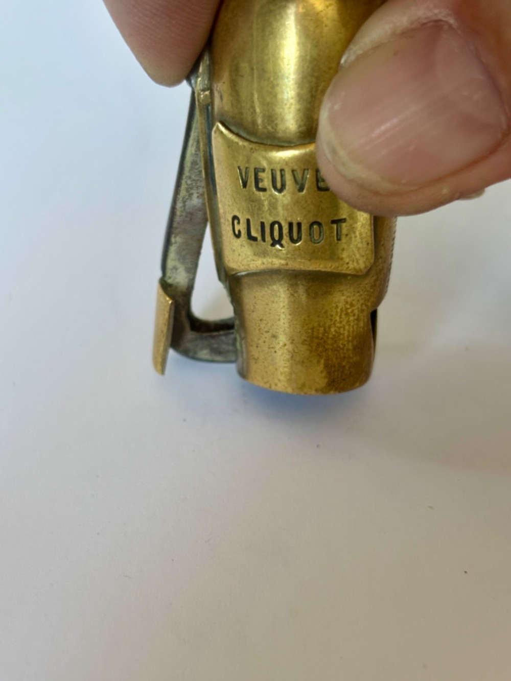 A nineteenth-century brass novelty vesta case and cigar cutter shaped like a champagne bottle with stamped Veuve Clicquot lettering. View IV