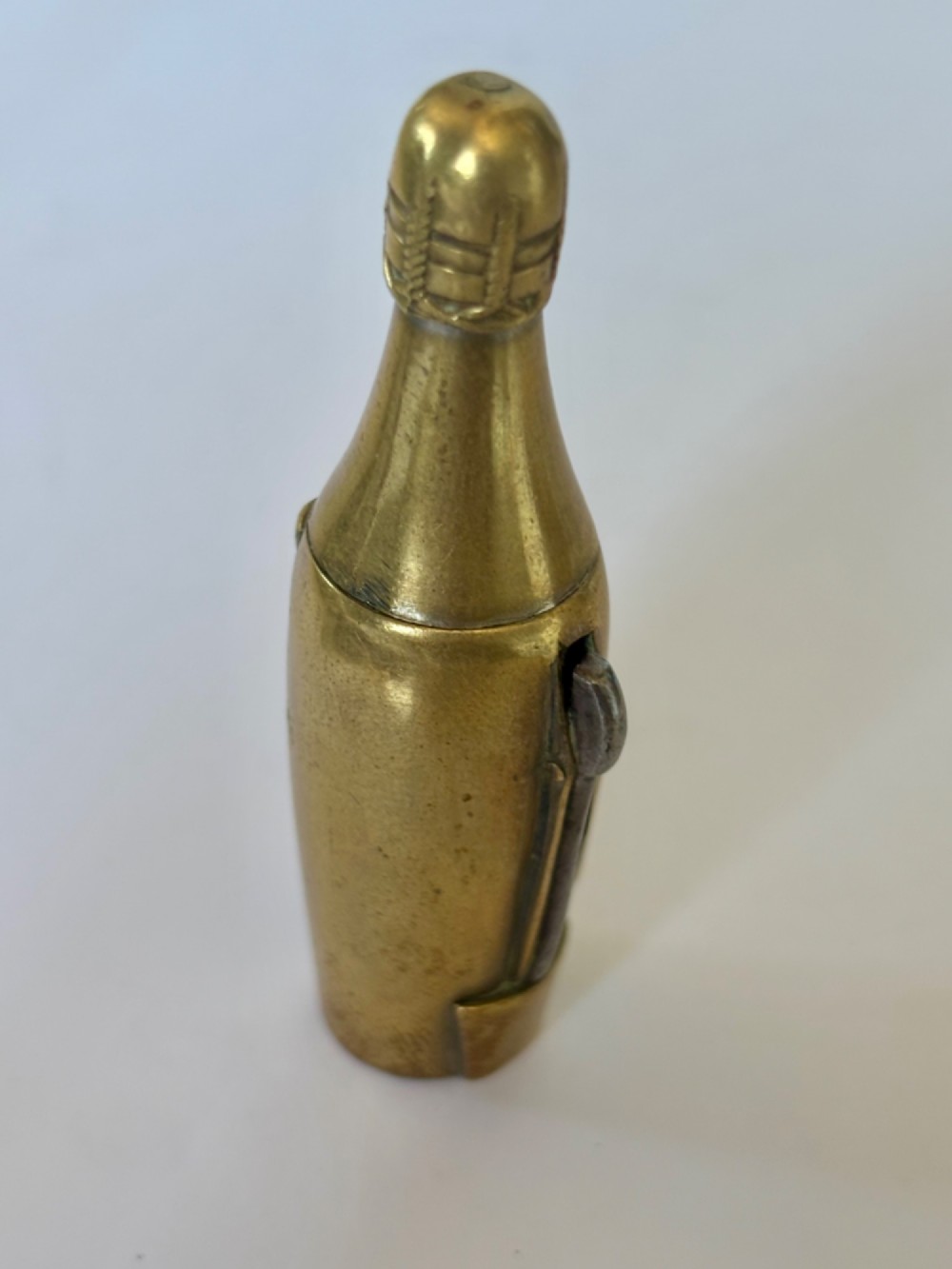 A nineteenth-century brass novelty vesta case and cigar cutter shaped like a champagne bottle with stamped Veuve Clicquot lettering. View V