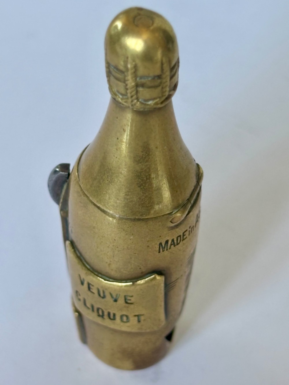 A nineteenth-century brass novelty vesta case and cigar cutter shaped like a champagne bottle with stamped Veuve Clicquot lettering. View VIII