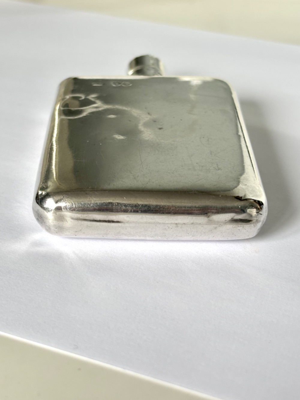 A Victorian sterling silver hip flask featuring an engraved crest, family monogram, and official British silver hallmarks. View VII