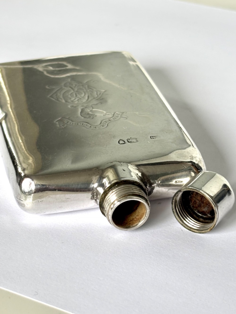 A Victorian sterling silver hip flask featuring an engraved crest, family monogram, and official British silver hallmarks. View VIII