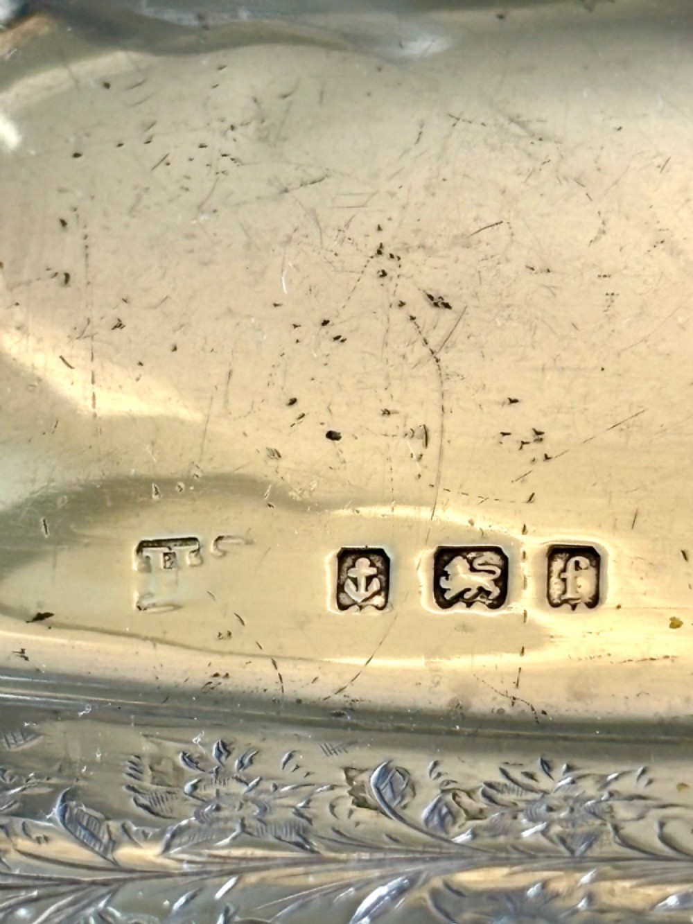 A pair of rectangular Edwardian sterling silver trinket dishes featuring pierced scrollwork borders and engraved floral decoration. View V