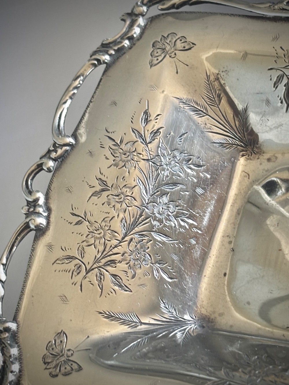 A pair of rectangular Edwardian sterling silver trinket dishes featuring pierced scrollwork borders and engraved floral decoration. View VI