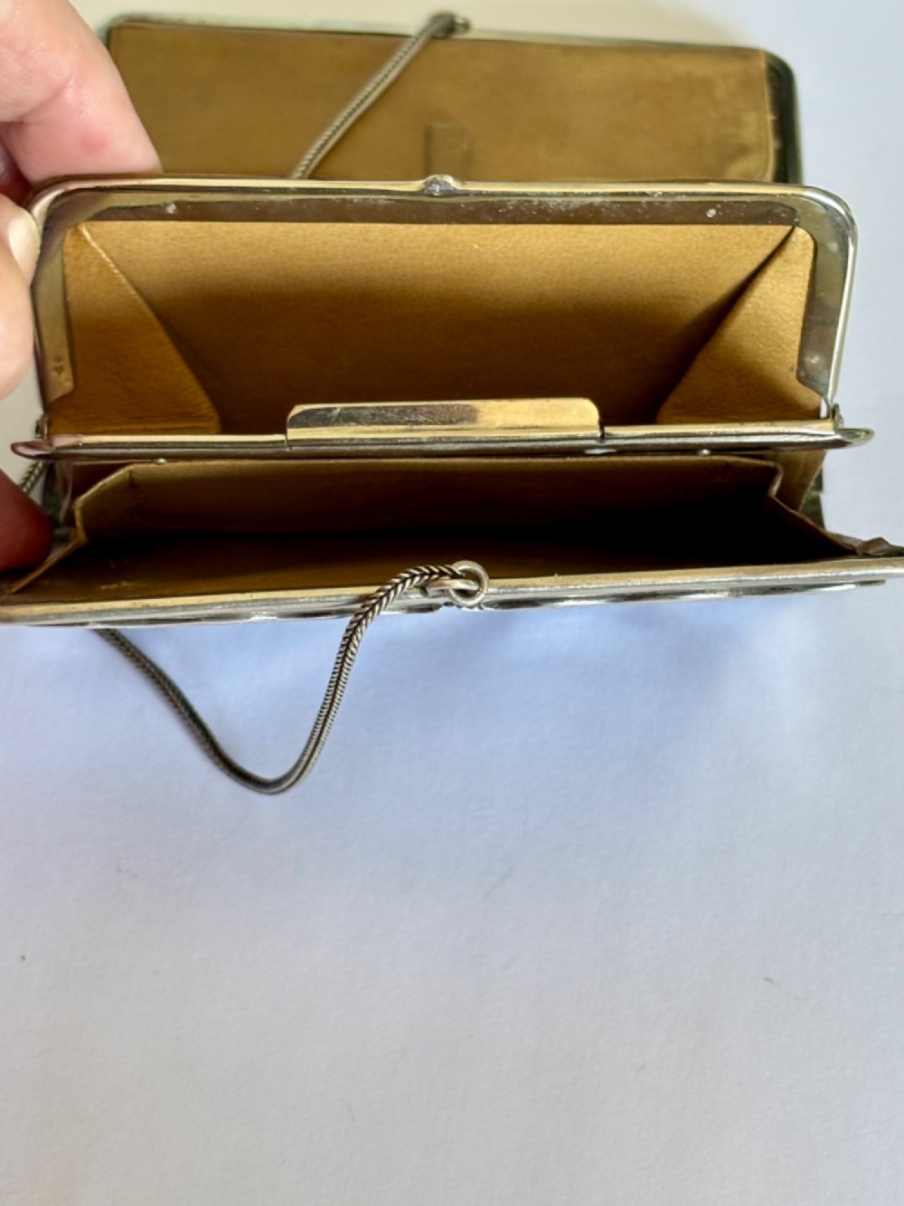 An Art Nouveau dark brown crocodile skin purse featuring hallmarked sterling silver whiplash corner mounts, a central silver cartouche with bow detailing, and a silver chain strap. View XI