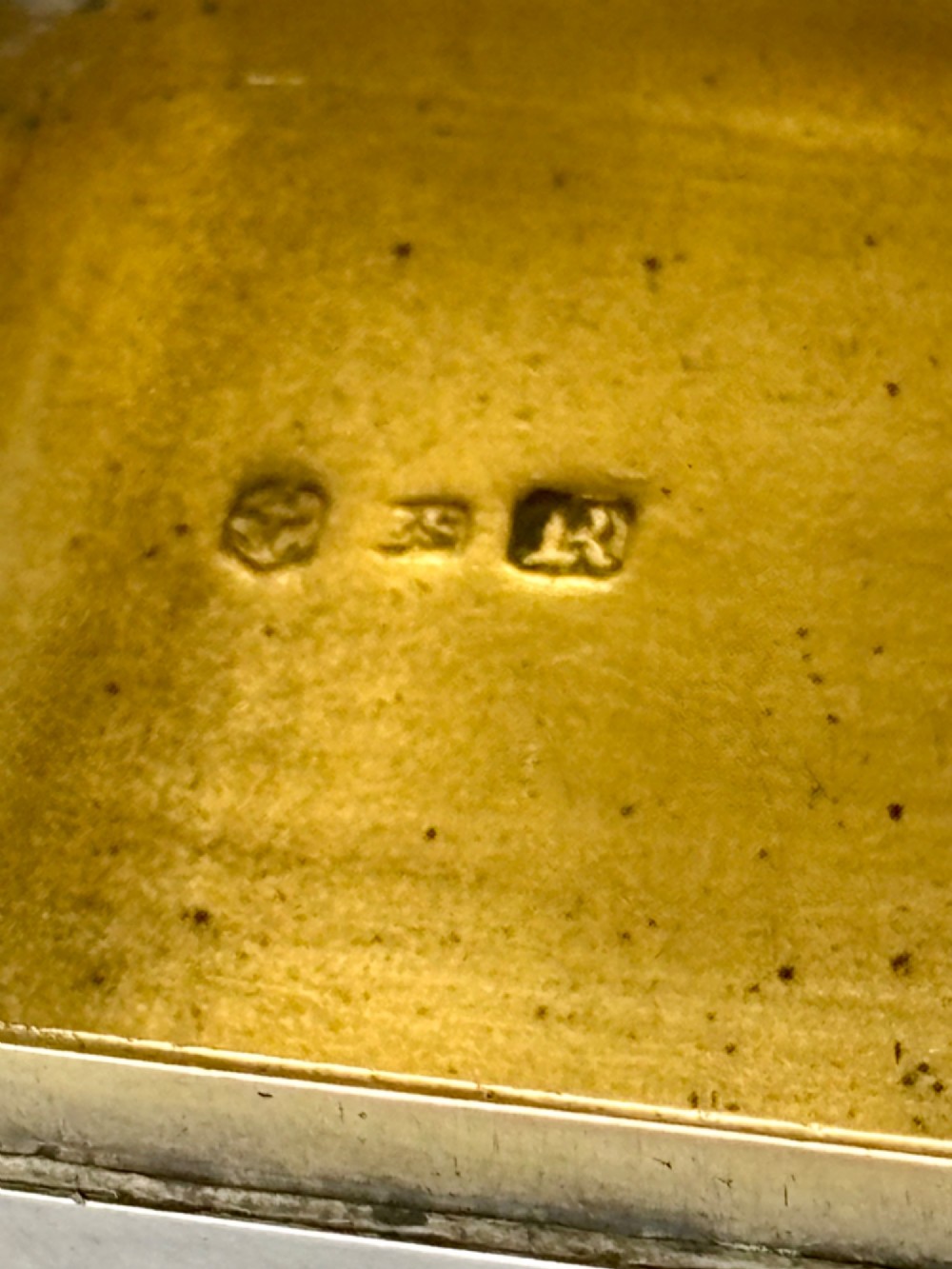 An early Victorian rectangular sterling silver gilt snuff box featuring engraved foliate scroll borders around a central crest on the hinged lid. View VII