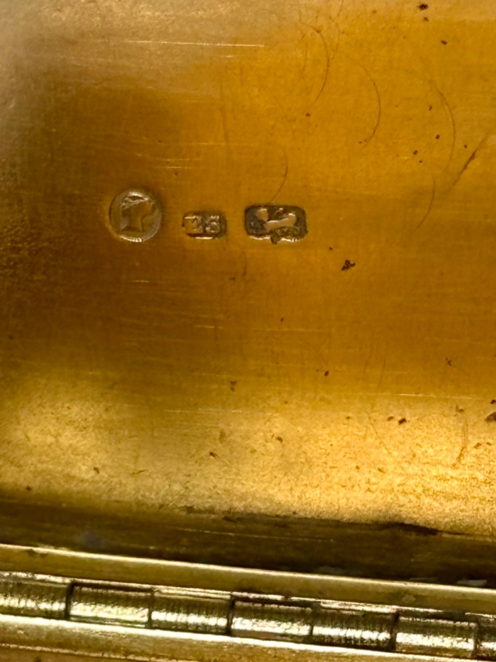 An early Victorian rectangular sterling silver gilt snuff box featuring engraved foliate scroll borders around a central crest on the hinged lid. View VIII