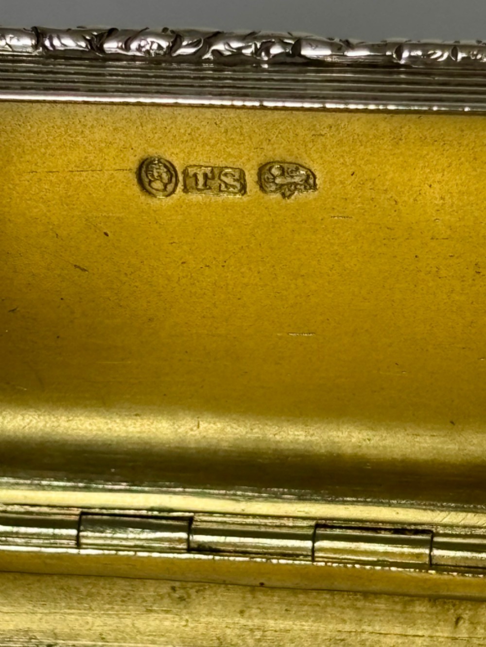 An open rectangular William IV silver gilt snuff box featuring reeded side panels, chased borders, and clear silver hallmarks inside the gilded lid. View III