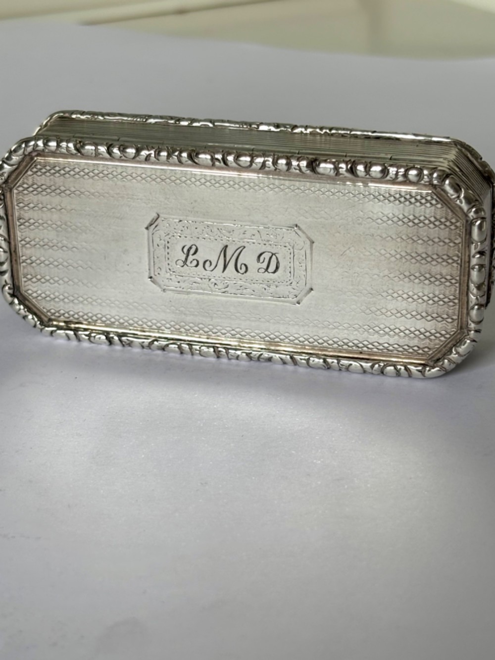 An open rectangular William IV silver gilt snuff box featuring reeded side panels, chased borders, and clear silver hallmarks inside the gilded lid. View V