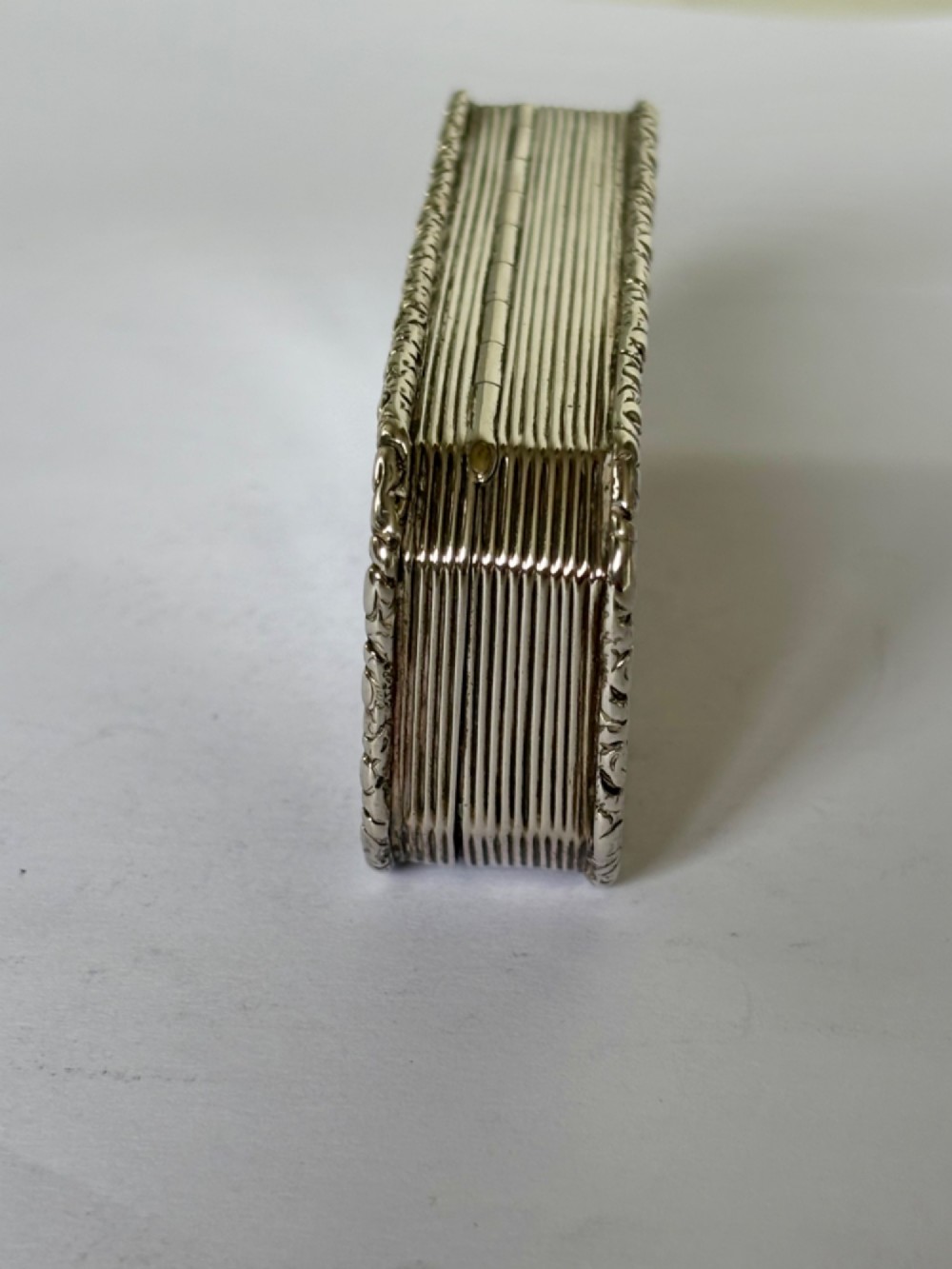 An open rectangular William IV silver gilt snuff box featuring reeded side panels, chased borders, and clear silver hallmarks inside the gilded lid. View IX