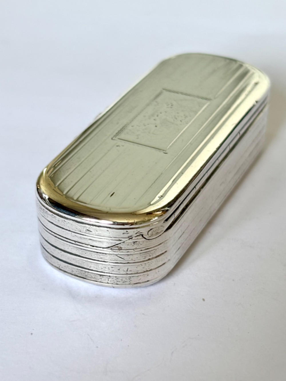 A Victorian silver gilt rectangular snuff box featuring engine-turned reeded decoration and a central rectangular cartouche on the lid.