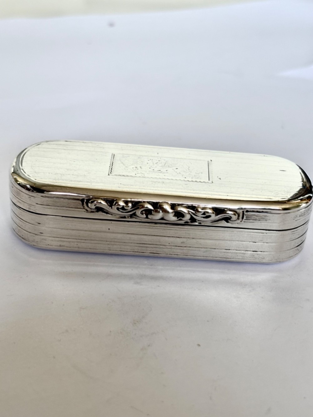 A Victorian silver gilt rectangular snuff box featuring engine-turned reeded decoration and a central rectangular cartouche on the lid. View V