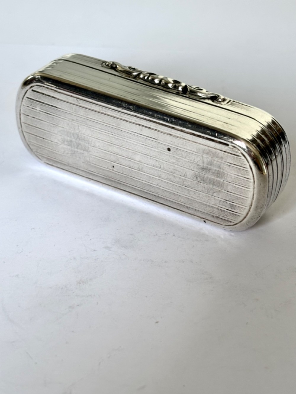 A Victorian silver gilt rectangular snuff box featuring engine-turned reeded decoration and a central rectangular cartouche on the lid. View VI