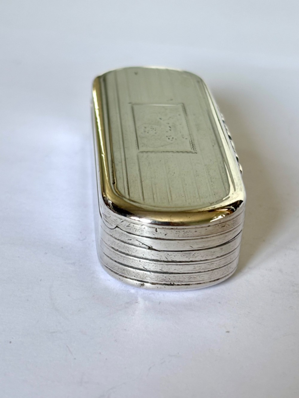 A Victorian silver gilt rectangular snuff box featuring engine-turned reeded decoration and a central rectangular cartouche on the lid. View VIII