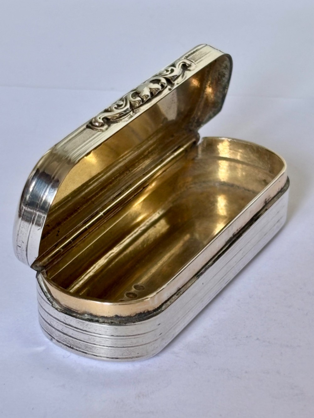 A Victorian silver gilt rectangular snuff box featuring engine-turned reeded decoration and a central rectangular cartouche on the lid. View XI