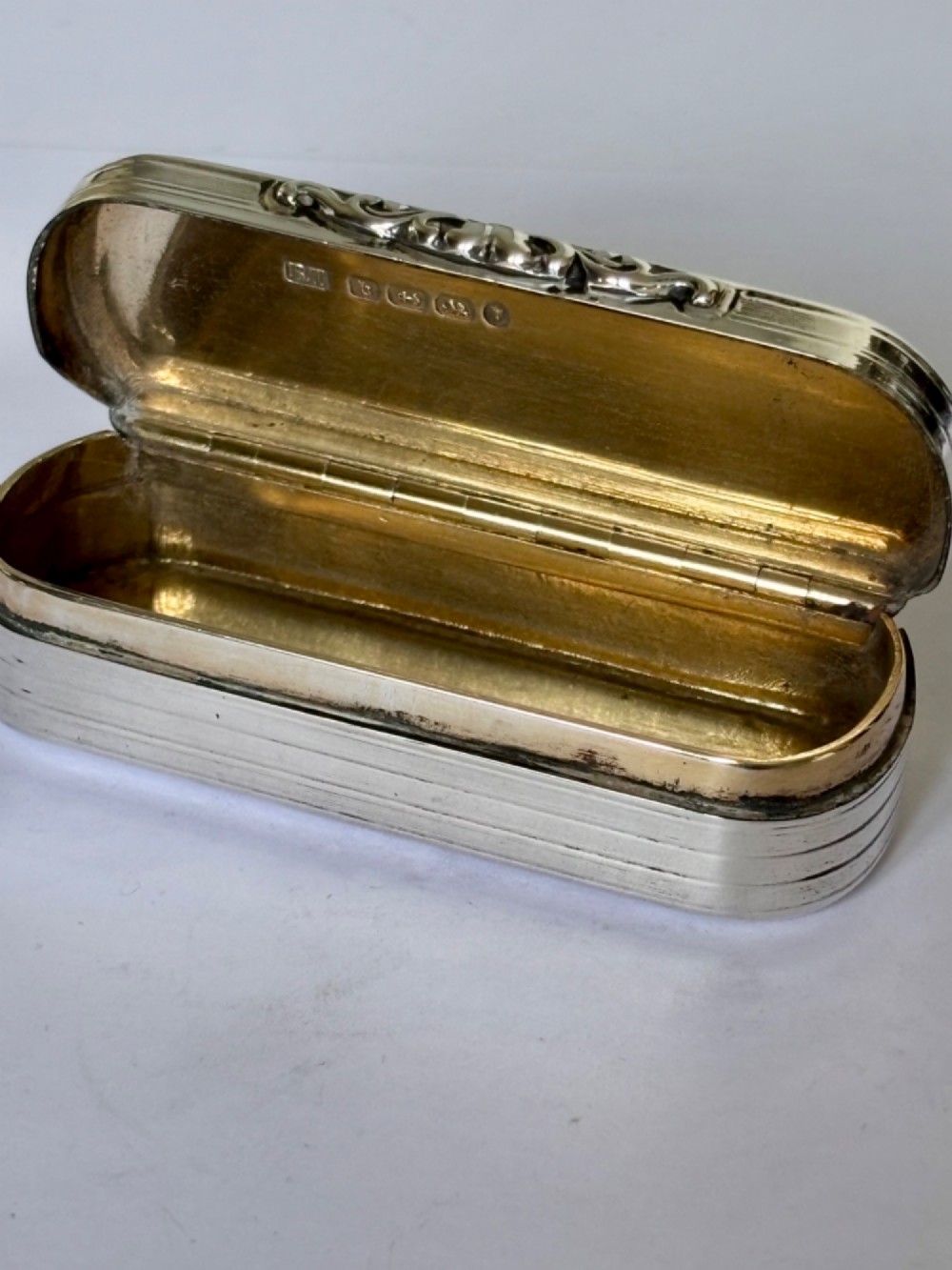A Victorian silver gilt rectangular snuff box featuring engine-turned reeded decoration and a central rectangular cartouche on the lid. View XII