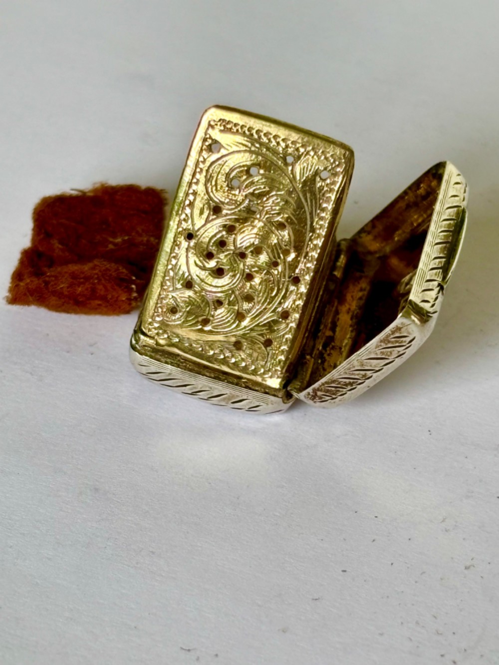 An early Victorian rectangular sterling silver vinaigrette featuring intricate foliate scroll engraving and a central unengraved cartouche. View X