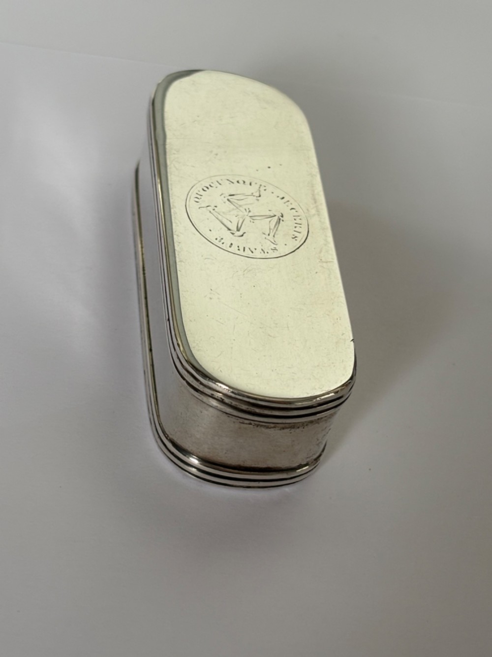 An elongated Georgian sterling silver snuff box with rounded ends, engraved on the lid with the Isle of Man triskelion crest. View III