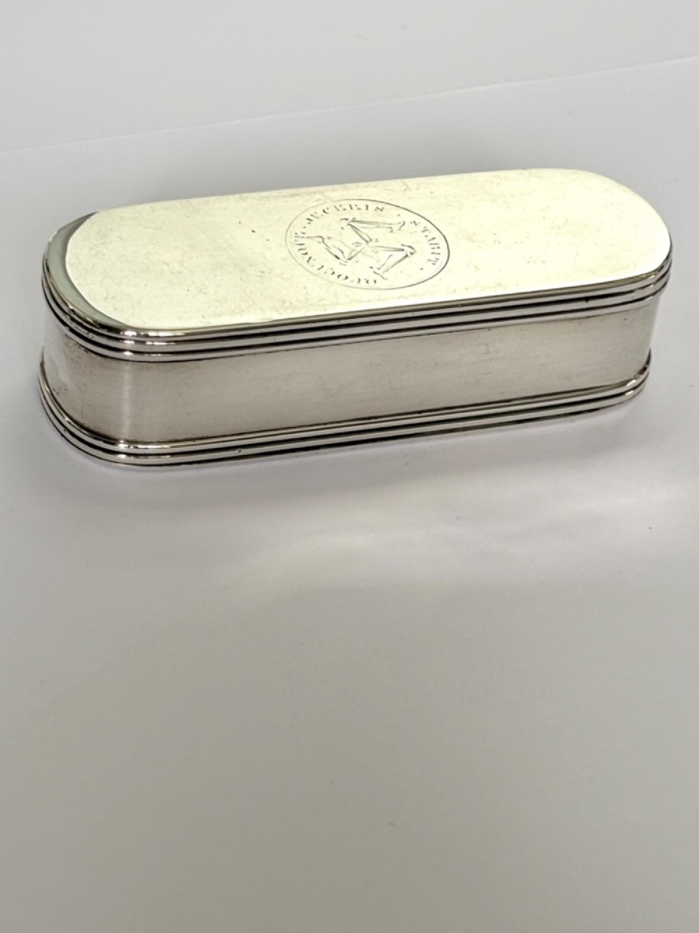 An elongated Georgian sterling silver snuff box with rounded ends, engraved on the lid with the Isle of Man triskelion crest. View V