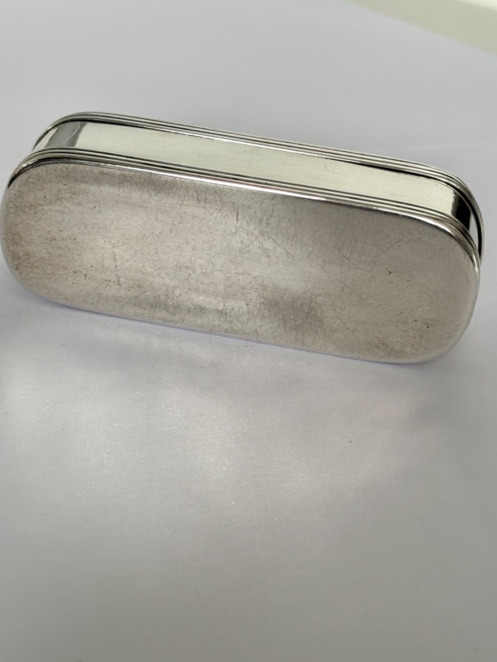 An elongated Georgian sterling silver snuff box with rounded ends, engraved on the lid with the Isle of Man triskelion crest. View VI