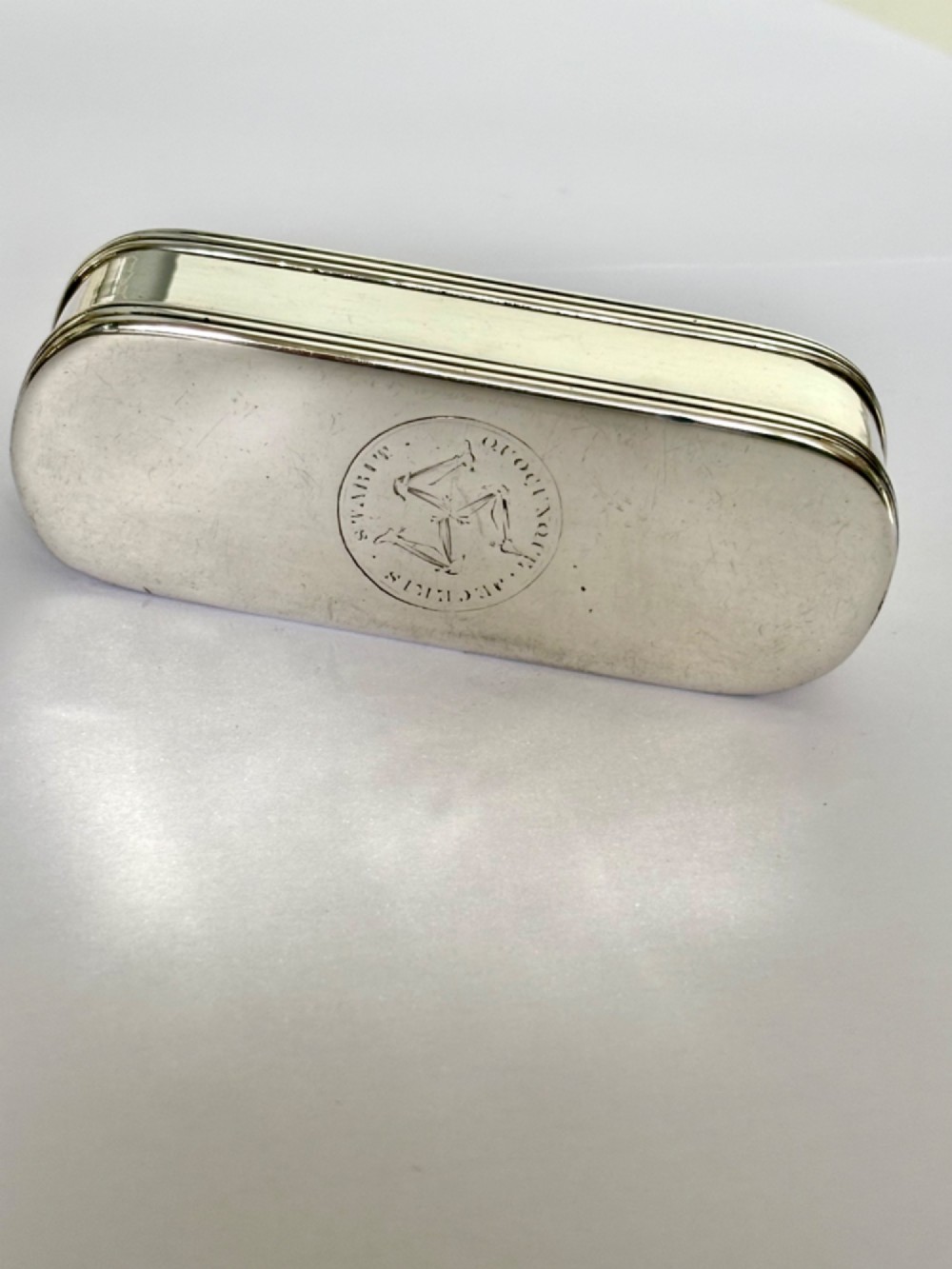 An elongated Georgian sterling silver snuff box with rounded ends, engraved on the lid with the Isle of Man triskelion crest. View XII