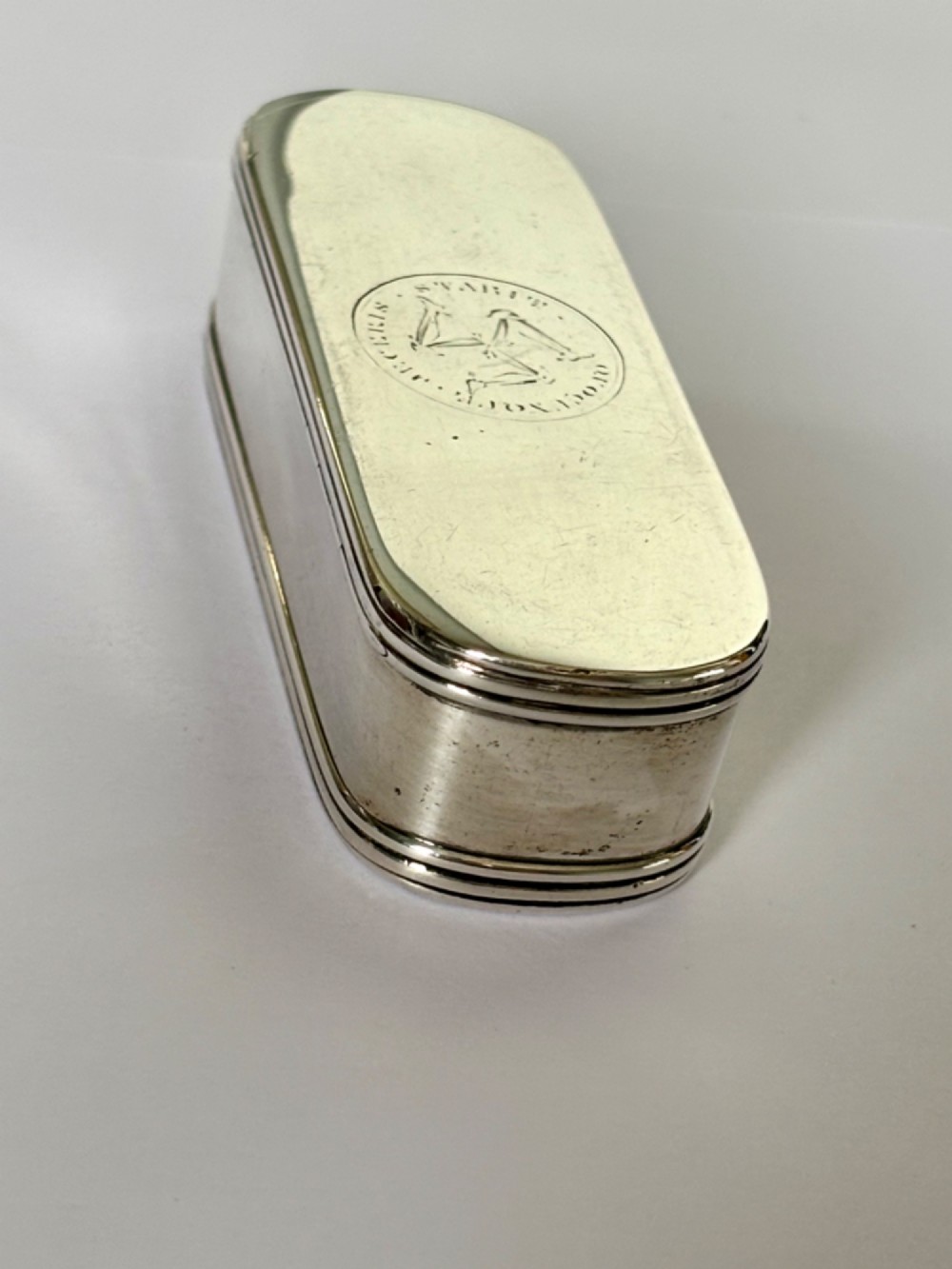 An elongated Georgian sterling silver snuff box with rounded ends, engraved on the lid with the Isle of Man triskelion crest. View XIII